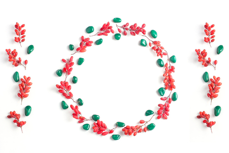 Frame of red berries on a white background. Simple flat lay composition, fall creative backgroundの写真素材