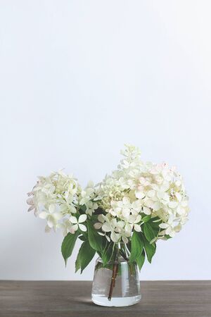 bouquet of white flower hydrangeas on a wooden background. vertical frame.の写真素材