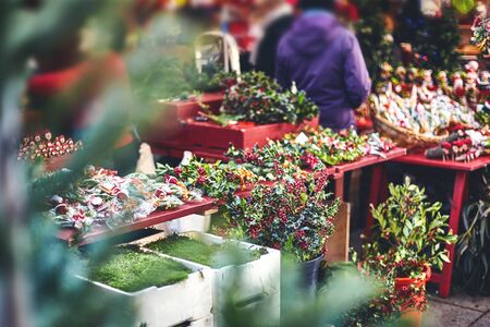 Holly branches with red berries in baskets at the Christmas market in Barcelona. varied new year decor.の写真素材