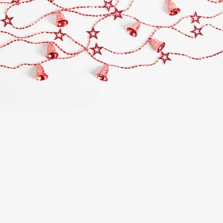 Christmas garlands with stars and bells red color on a white background. flat lay, square frame, copy space.の写真素材