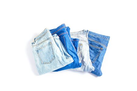 set of jeans trousers of different colors on a white background. flat lay, top viewの写真素材