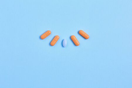 medicine creative concept. vitamins and pills to maintain healthy skin and hair. simple flat lay on a blue background, copy spaceの写真素材