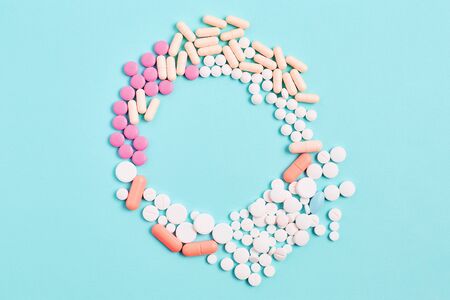 the frame of medicines in the form of tablets and capsules, different shapes on a blue background. vitamins for skin, hair, and nails. wellness concept. flat lay, copy space.の写真素材