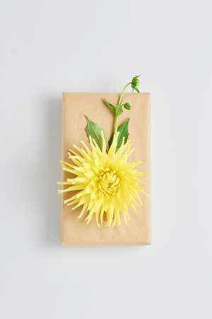 the birthday concept. beautiful gift packaging with a yellow flower, top view on a white background
