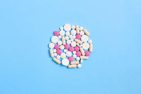 composition of pills on a blue background. vitamins for skin, hair, and nails. wellness concept. creative layout.の写真素材