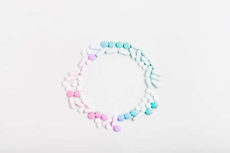 minimal concept. frame of pills and capsules of pastel gradient color on a white background. vitamin skincare, creative layout, copy space.の写真素材