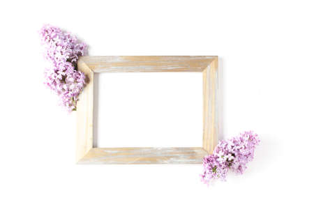 gold frame decorated with lilac flowers on a white background. minimalistic composition, space for text, flat lay.の写真素材
