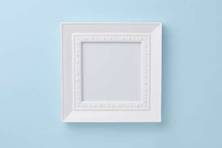 beautiful white photo frame on a blue background. simple composition for layout, place for text,...