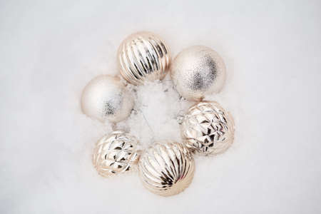 beautiful minimalistic christmas composition with golden decor. festive decoration in the form of balls on white snow. copy space.の写真素材