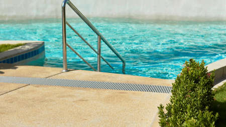 beautiful turquoise water in the pool surrounded by tropical greenery. fun summer vacation concept. long banner mockup.の写真素材