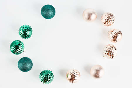 festive Christmas frame of toys in the shape of a ball of green and gold color on a white background. flat lay with place for text.の写真素材