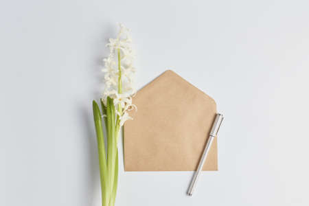 simple arrangement of hyacinth flower and craft envelopes. minimalistic workplace. layout for...