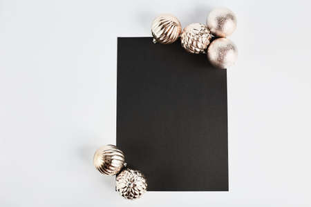 new year and christmas white background and gold ball decor. mock up for text on a black notebook with space for text, flat lay.の写真素材