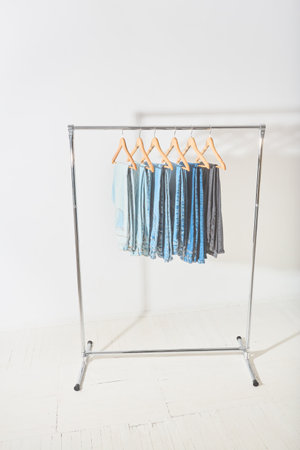 light minimalistic studio with a mobile clothes hanger. clothes rail with jeans of different colors hanging on hangersの写真素材