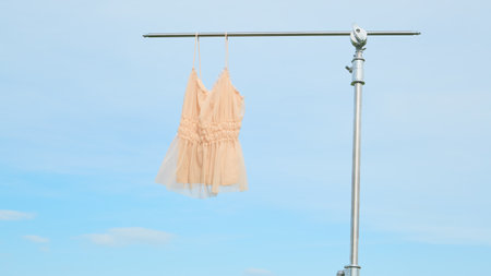 A beautiful dress is showcased against a clear blue sky, ideal for spring holidays. layout or mockup for fashion products.の写真素材