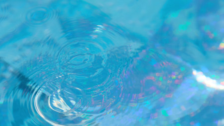 Bright sunlight reflects off the water surface, forming colorful patterns. Gentle ripples disturb the tranquility of the blue water, creating an enchanting visual effect.の写真素材