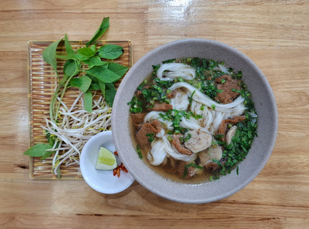 Vietnamese vegetarian pho with tofu, mushrooms, and noodles in a light broth, top view