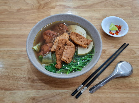 Traditional Vietnamese vegetarian soup with soy meat, tofu, green vegetables, and flavorful broth....