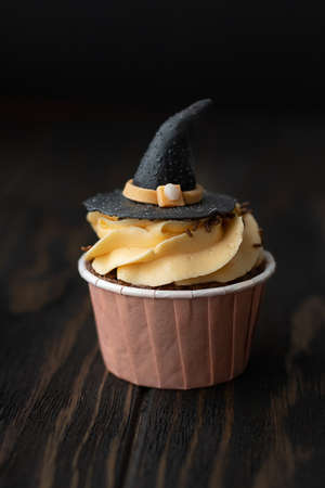 Cupcake in the form of a witch hat on a dark background. Halloween concept.の写真素材