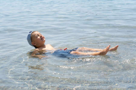 The child learns to swim. Happy child swims in the sea. Holidays in Greece. Happy childhood conceptの写真素材