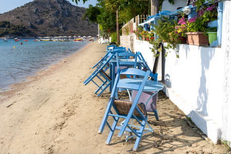 Closed cafe and folded chairs in a Greek seaside resort.の写真素材