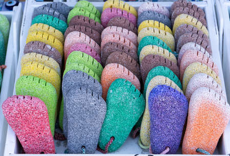 Multicolored pumice stones in the form of legs at a beach shop in Greece.の写真素材