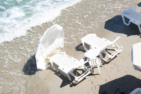Storm on the beach in Greece. Inverted sun umbrellas and sun loungers.の写真素材