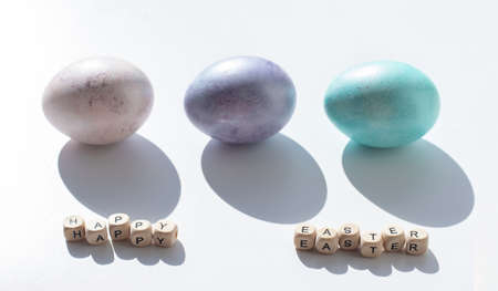Easter concept. Pink, purple and blue eggs on a white background. minimalism. hard shadowsの写真素材