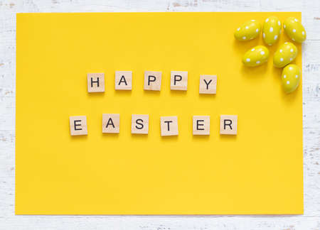 Inscription Happy Easter on the yellow background with yellow eggs. minimalismの写真素材