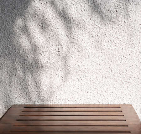 Shadow from palm leaves on a white wall in a tropical resort. hard shadows. Mockup, copyspace.