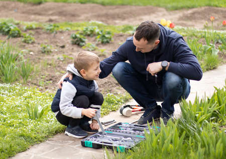 Father and son are repairing a street lamp. The boy helps his father. International Fathers Day conceptの写真素材