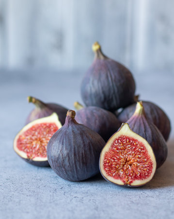 Fig fruits, whole and halves, on a gray background.の写真素材
