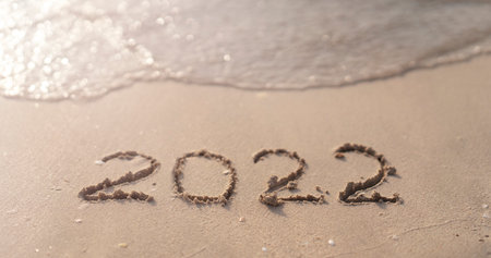 The numbers 2022 are washed away by the sea waves of the Persian Gulf. The concept of a change of...