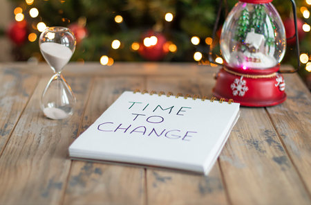 Hourglass and notepad with motivational inscription - Time to change. Striving for change, push for...