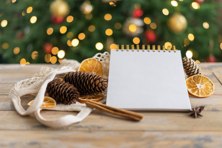 Notepad with copy space on the wooden background and natural Christmas decoration. mockup. Eco friendly concept.の写真素材