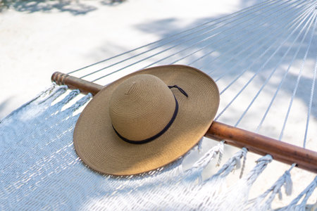 A straw hat lying on the hammock in the Maldives. Travel and tropical vacation concept.の写真素材