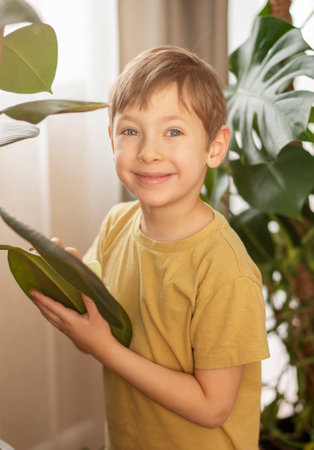 A little boy helps with cleaning around the house and taking care of the plants. Spring cleaning concept.の写真素材