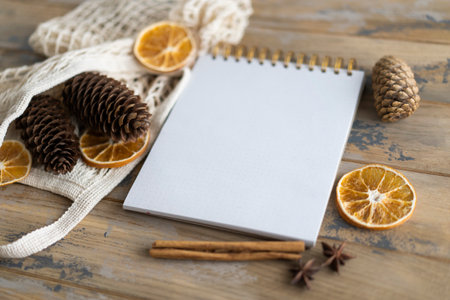 Notepad with copy space on the wooden background and natural Christmas decoration. mockup. Eco friendly concept.の写真素材