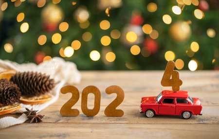 Wooden numbers 2024, toy car carries the number 4の写真素材