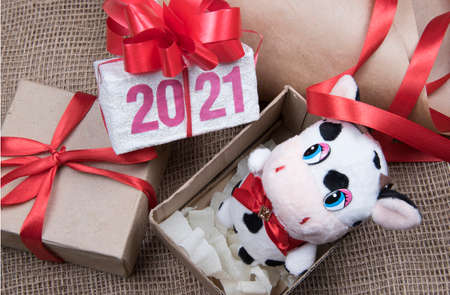 2021 figures on Christmas gift box. Cow bull toy New Year symbol packaging in box. Hand made craft gift boxes of paper at Christmas holiday. Top view.の写真素材