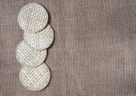 Wicker straw stands on gunny background. Flatlay, topview, copyspace, minimalism, natural eco conceptの写真素材