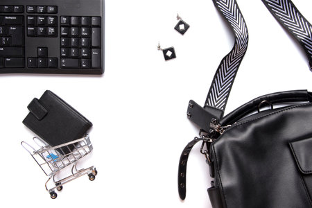 Flat lay collage of keyboard, women's bag, cardholder in shopping cart isolated on white background....