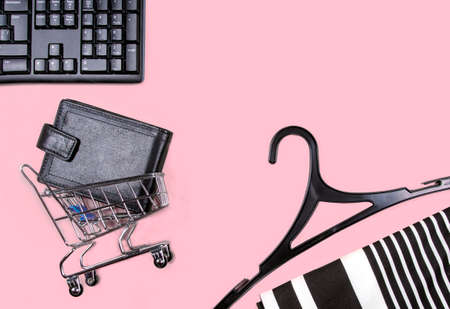 Flat lay collage of keyboard, hangers, cardholder in shopping cart isolated on pink background. Buy...