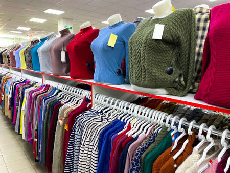 Women's sweaters on display in store. Classic female pullovers in shop. Shopping concept