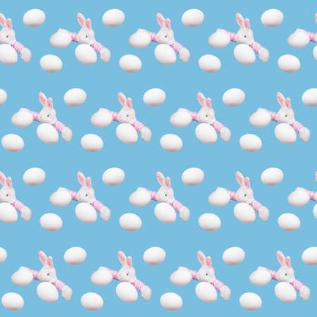 Seamless pattern with easter eggs and toy bunny rabbit on blue background.
