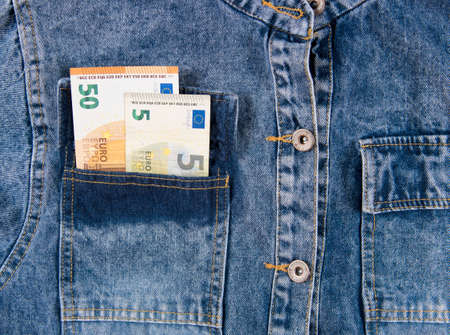 Fifty euro notes in pocket of blue jeans shirt. European union money bills in jeans pocket, closeup.の写真素材