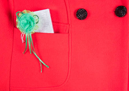 Gift box in pocket of red women's coat, closeup. Holiday congratulation concept. Flat lay, upper view.の写真素材