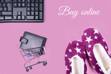 Flat lay collage of keyboard, slippers, cardholder in shopping cart isolated on pink background. Buy online on internet concept.の写真素材
