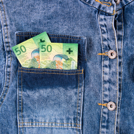 Fifty euro Swiss franc notes in the back pocket of blue jeans shirt. Swiss franc.money bills in jeans pocket, closeup.の写真素材