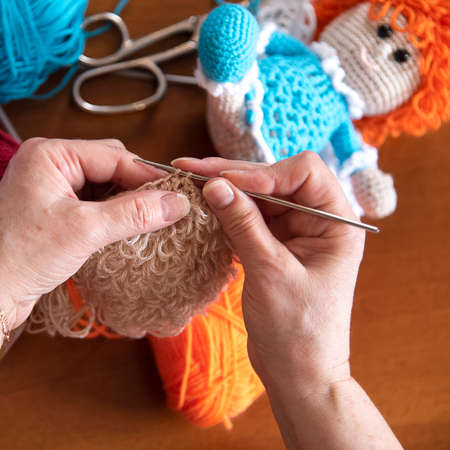 Female hands holding crochet hook. Home activities during quarantine. Diy toys. Woman knitting.の写真素材